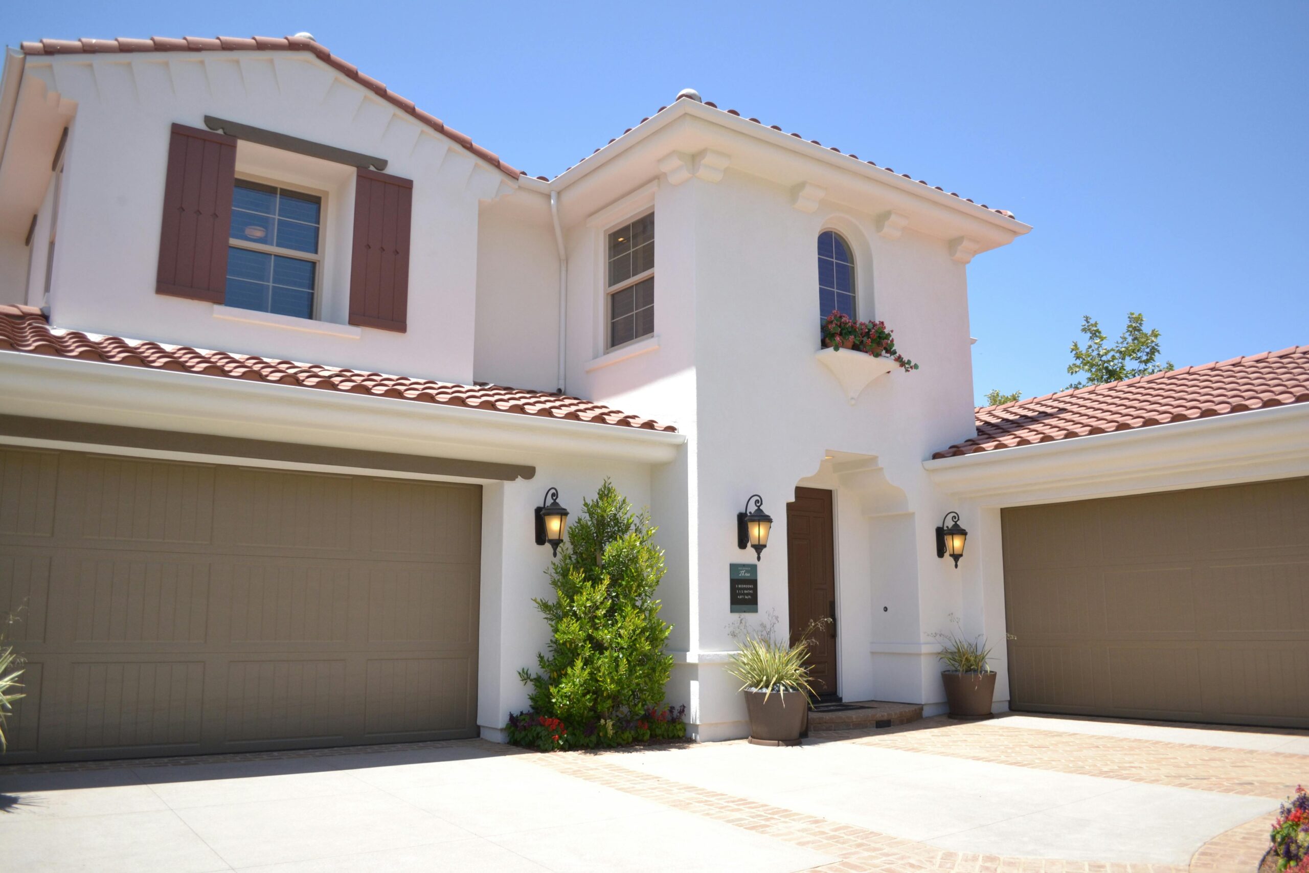 A spacious house featuring two prominent garage doors, showcasing a modern architectural design.