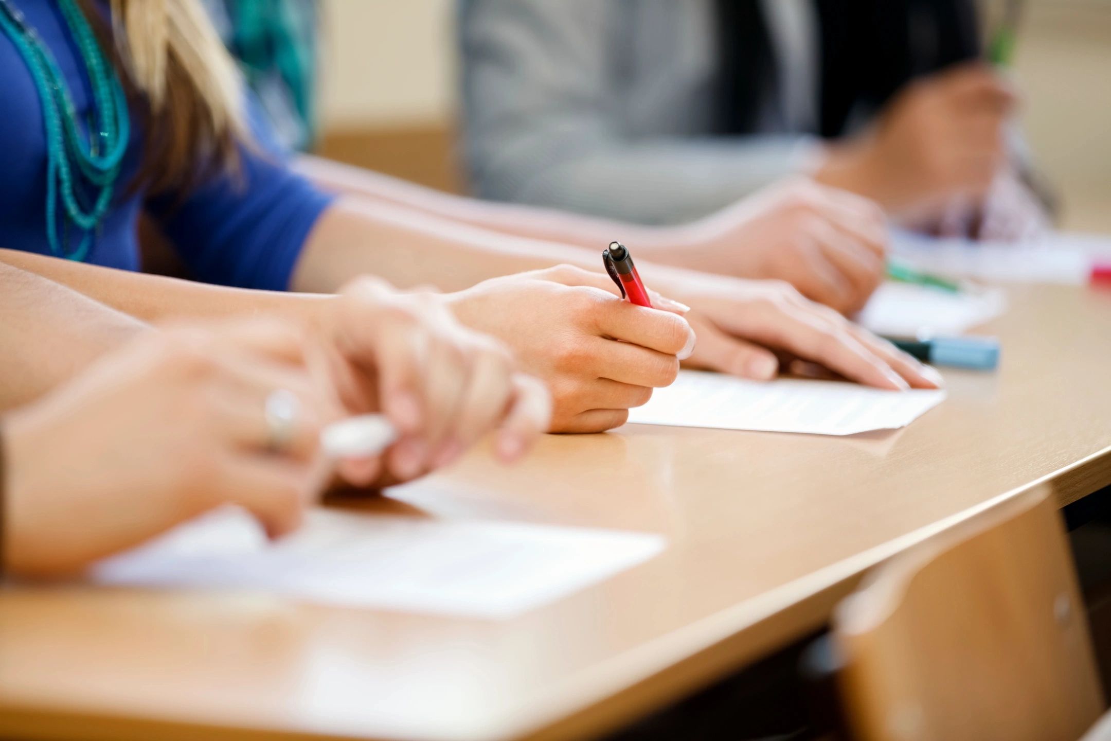 A team of individuals at a table, each with a pen in hand, focused on a collaborative task or discussion.