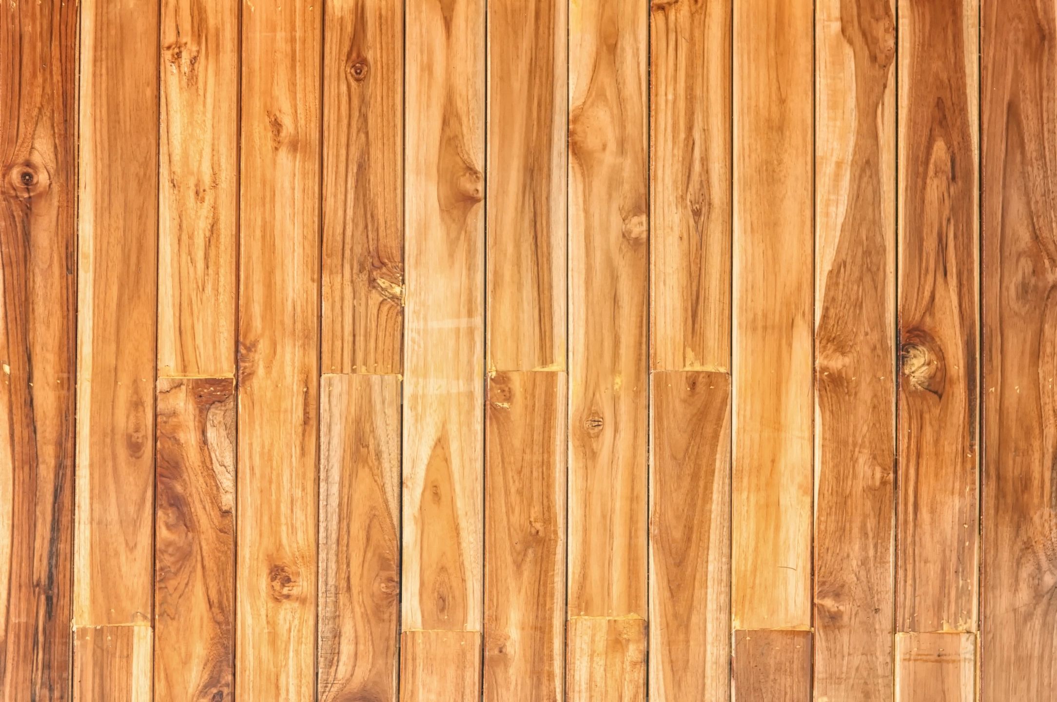 A wooden wall background featuring a mix of light wood planks, creating a warm and natural aesthetic.