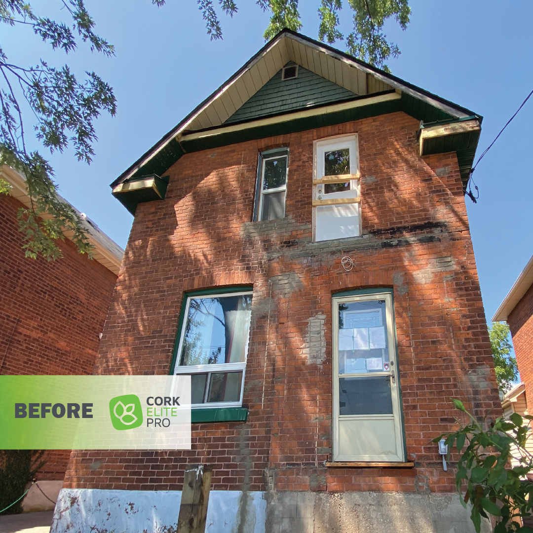 A brick house with visible crumbling and weathered bricks, showing signs of deterioration and structural wear.