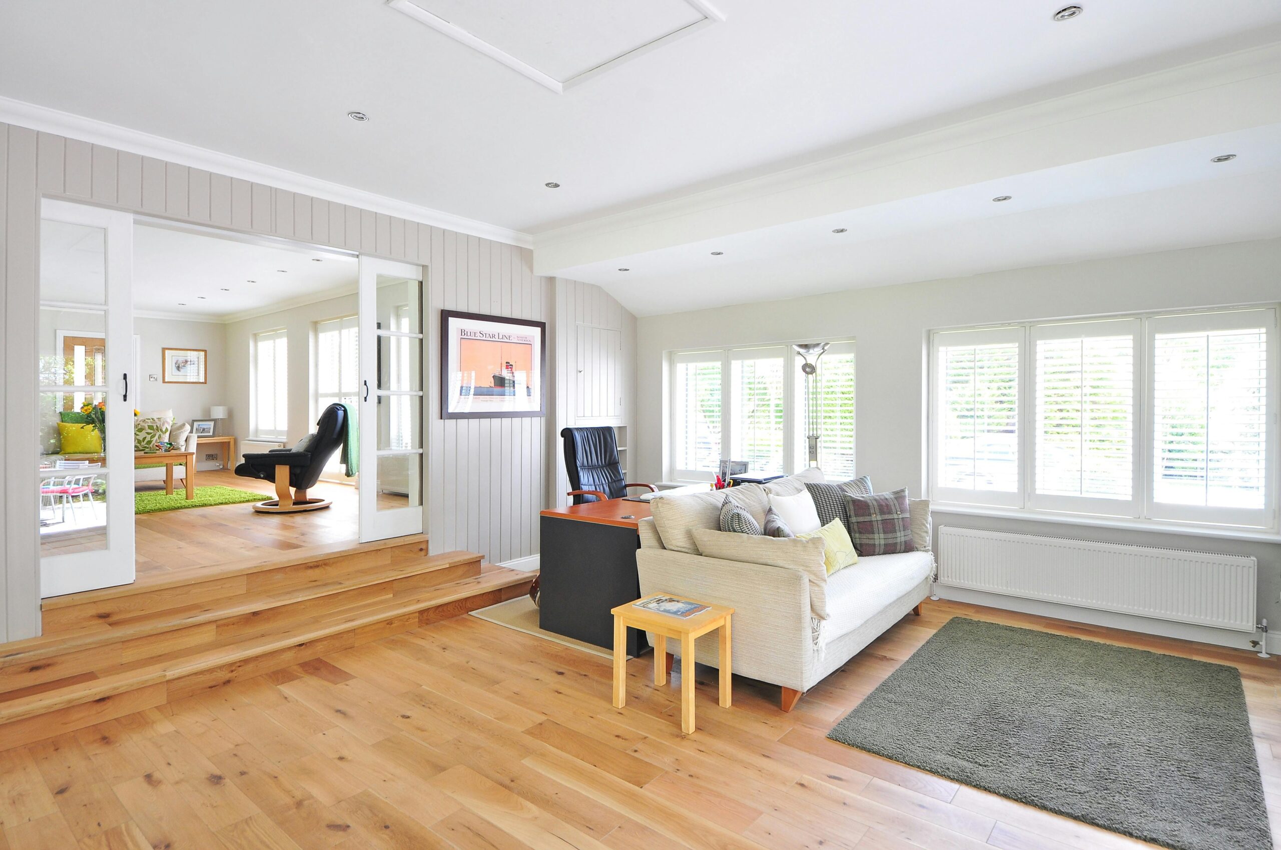 A cozy living room featuring a comfortable couch, a stylish coffee table, and hardwood flooring covering hex heat in floor heating