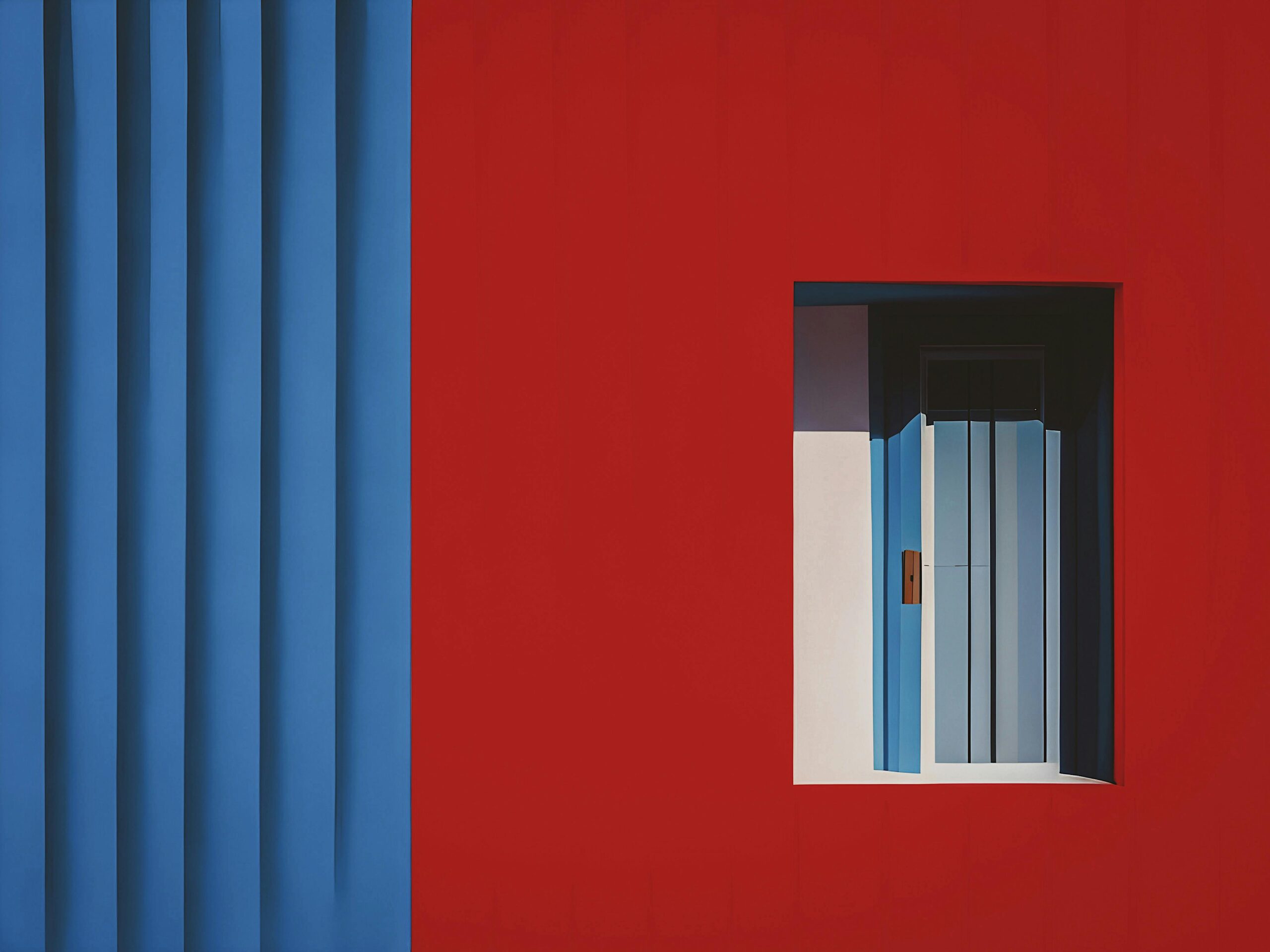 A vibrant red and blue wall featuring a window and a door, creating a striking visual contrast.